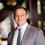 adam-heller Adam Heller, a professional specializing in tax grievance consulting. He has short brown hair, and is wearing a white collared shirt, with a blue tie and a light gray suit jacket.